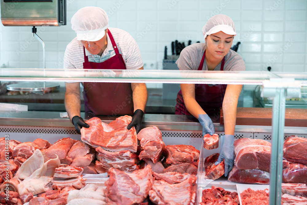 Ταπετσαρία In local butcher shop, elderly male seller prepares order of pork ribs for regular customer