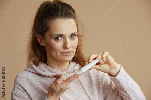 woman with herpes on lips on beige background photo