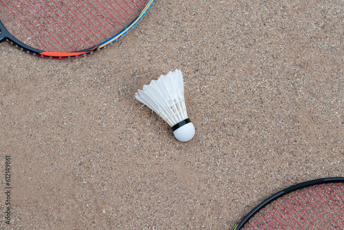 Badminton equipments, rackets and white cream shuttlecocks, on sand floor of outdoor badminton court, selective focus, concept for outdoor activity and outdoor sports for health. © Sophon_Nawit