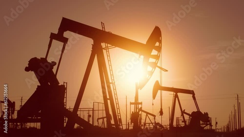 The sun rises behind a large oil field in California. photo