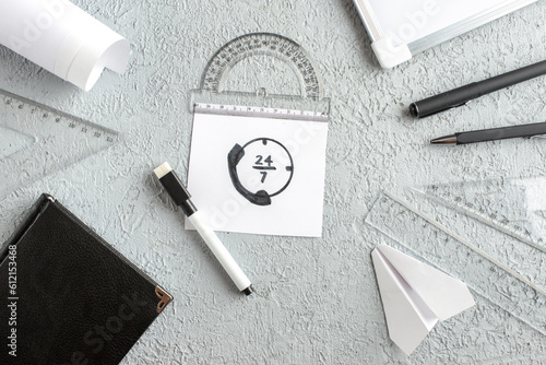 Overhead view of call line on white sheet and black notebook paper plane pens ruler desk blank on gray sand background photo