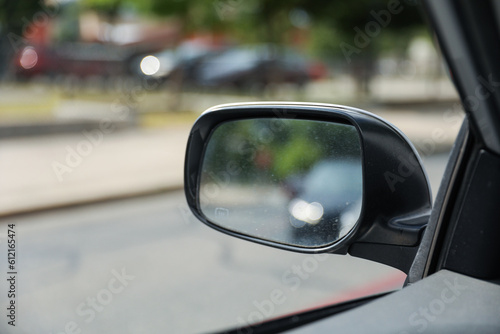 A car mirror reflects the journey ahead, symbolizing self-reflection, perspective, awareness, and the constant pursuit of progress