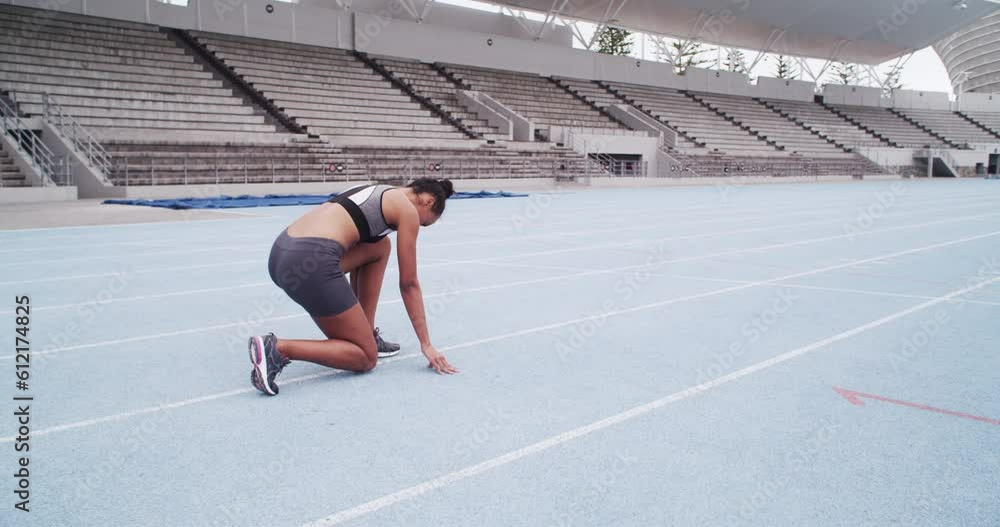 Woman, start position and running for sports, race and speed on stadium track from the back in Cape Town. Female athlete, runner and ready to sprint for fitness, training and cardio event in arena Woman, start position and running for sports, race and speed on stadium track from the back in Cape Town. Female athlete, runner and ready to sprint for fitness, training and cardio event in arena