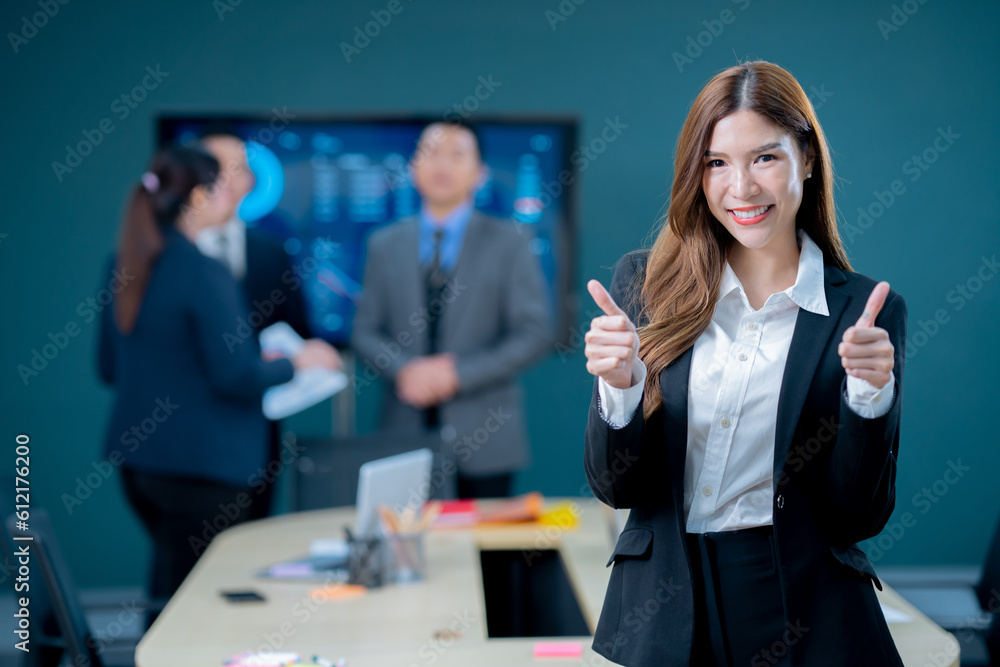 Successful young businesswoman executives and business women are standing confident in the office in front of their team.