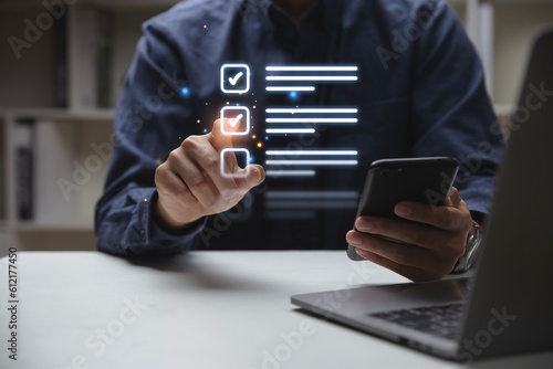 Hand of young man holding a pen pointing to mark correct sign for quality document control checklist and business approve concept.