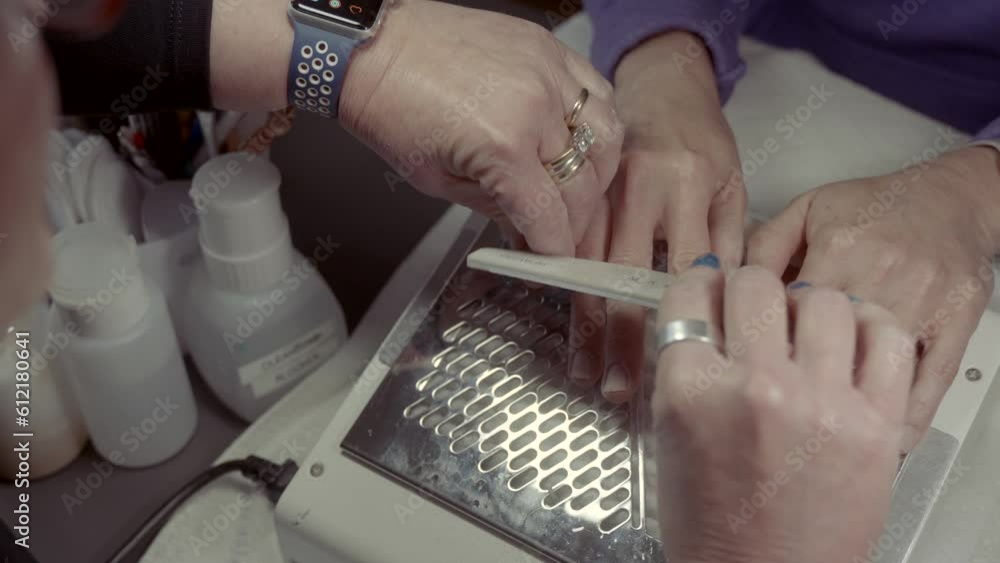 Using a fingernail file to shape nails during a manicure Using a fingernail file to shape nails during a manicure