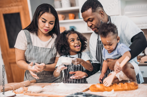 Family members cook homemade pizza dough in funny and playful  ways. Mixing ingredients like salt  sugar  milk  yeast  oil then rubbing  massaging  pressing bread flour to make it smoother  stretchier