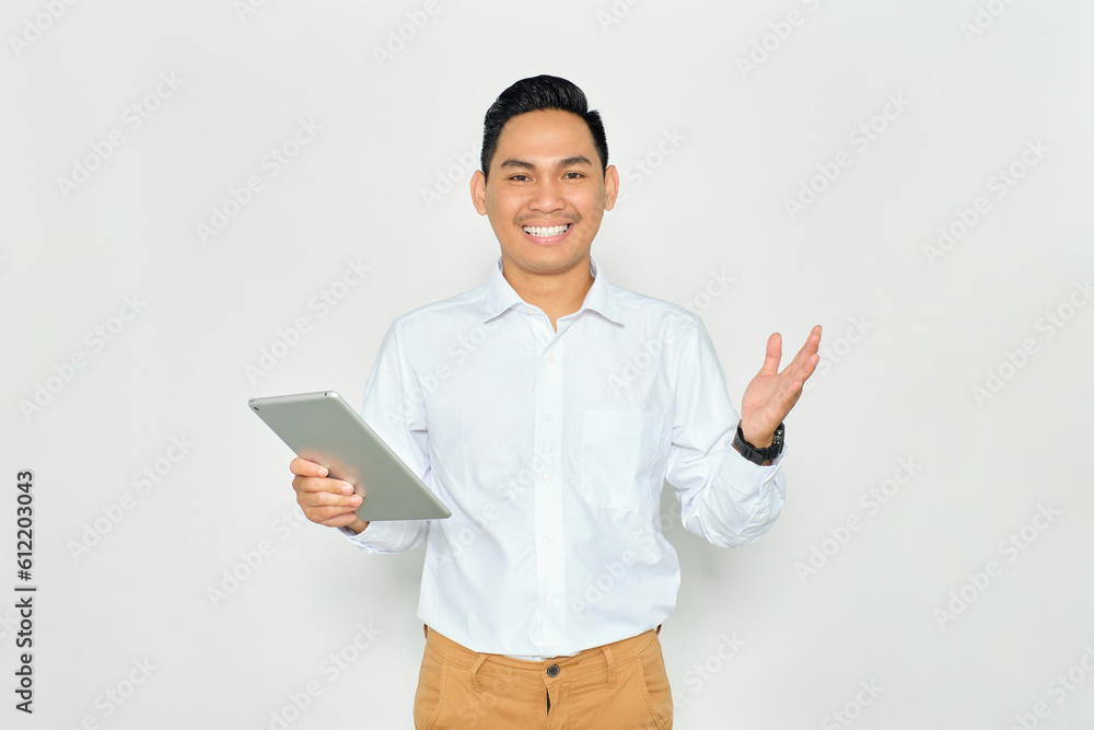 Portrait of happy young Asian man in formal wear holding digital tablet and looking at camera with toothy smile isolated on white background Portrait of happy young Asian man in formal wear holding digital tablet and looking at camera with toothy smile isolated on white background