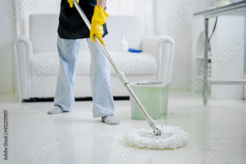 young woman mopping the floor cleaning at home smiling cheerful.cleaning staff cleaning concept