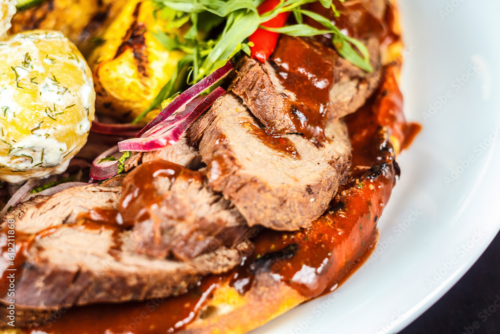 A plate of meat and vegetables with sauce on it A plate of meat and vegetables with sauce on it