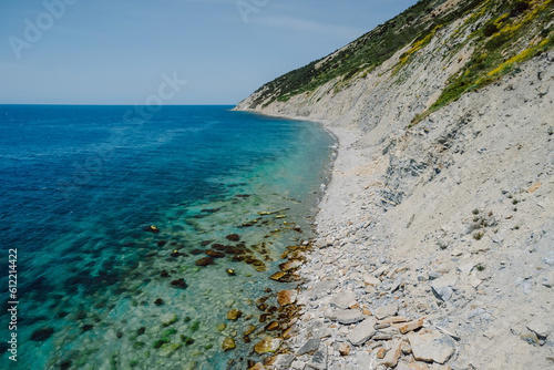 Aerial view of coastline with transparent blue sea and stone beach. Summer day in Montenegro