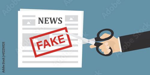 Reader hand uses scissors and cuts newspaper with fake news. Articles in press with lies and hoax. Refuse from false mass media and propaganda. Stop fake news and disinformation.