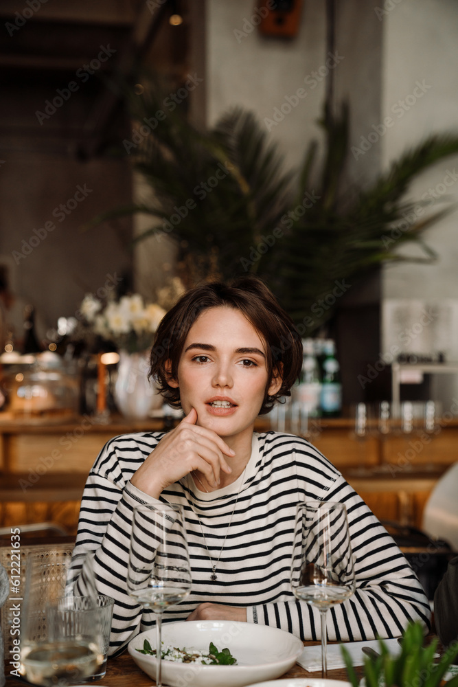 Portrait of young woman sitting at table in restaurant Portrait of young woman sitting at table in restaurant