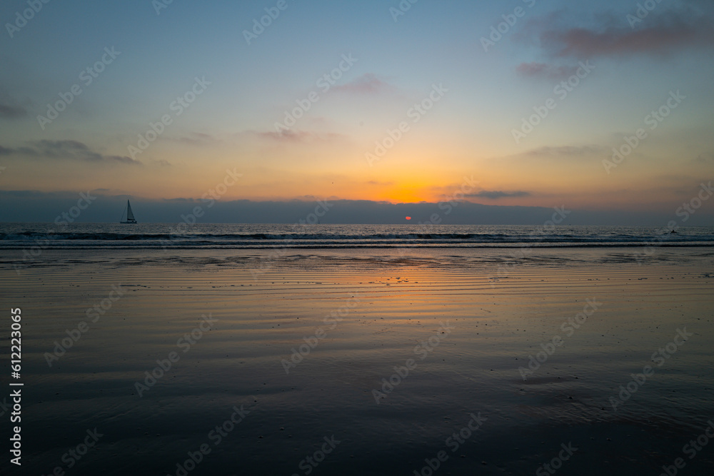 Calm sea with sunset sky and sun through the clouds over. Ocean and sky background, seascape.