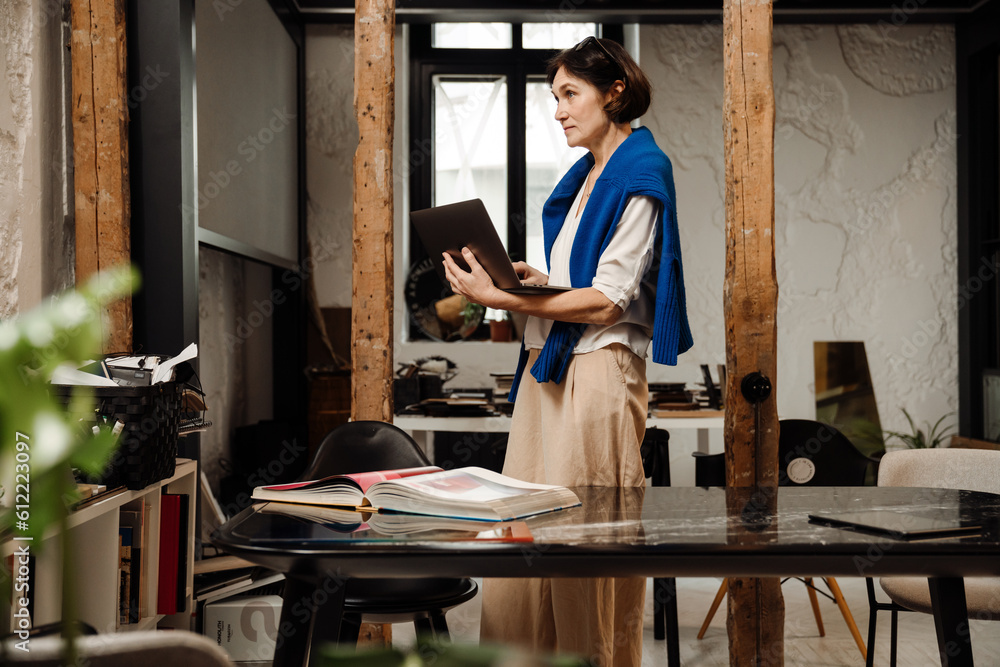 Woman architect working on laptop in office Woman architect working on laptop in office