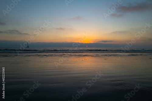 Calm sea with sunset sky and sun through the clouds over. Ocean and sky background  seascape.