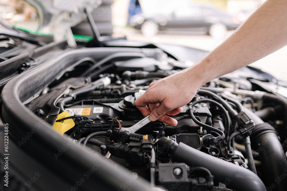 Auto mechanic working in garage. Human hands hold tools. Repair service concept Auto mechanic working in garage. Human hands hold tools. Repair service concept