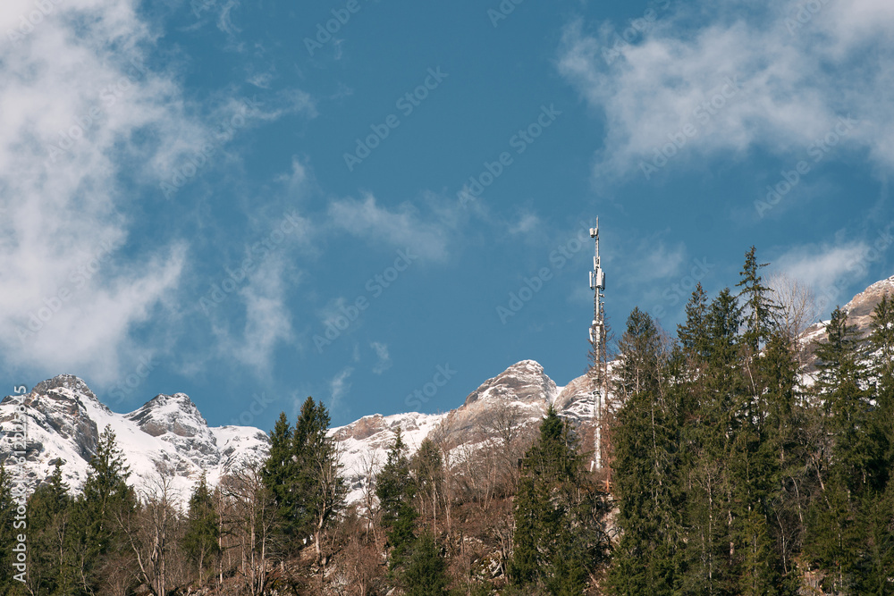 Fototapeta premium Telecom Tower 5G and 4G Cellular Networks in the sky. cell tower over a forested rural area