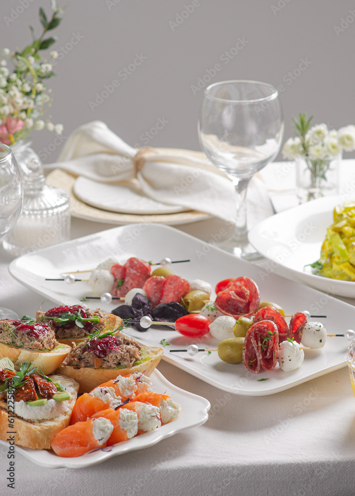 Festive table with white tablecloth and appetizers Festive table with white tablecloth and appetizers