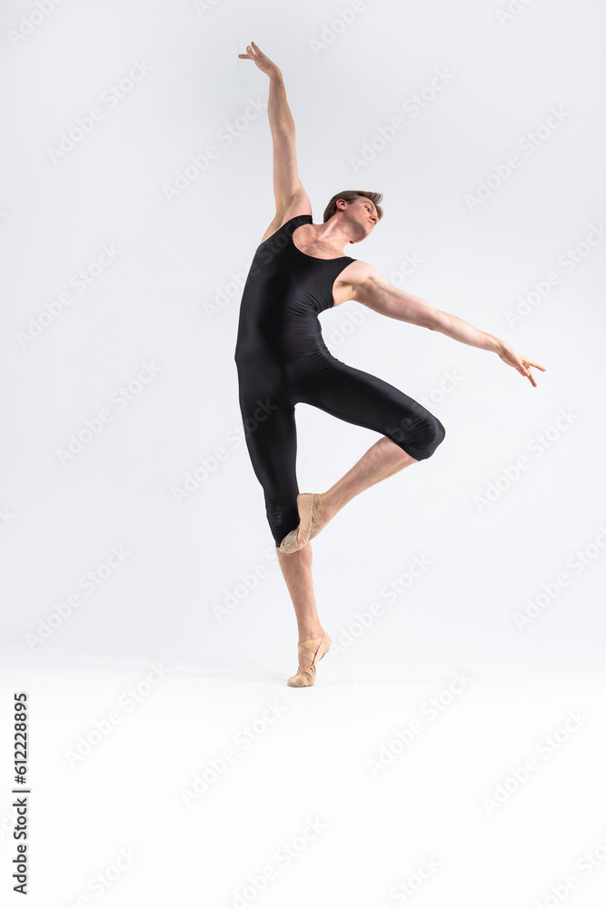 male Ballet Dancer Young Athletic Man in Black Suit Posing in Ballanced Stretching Dance Pose Studio On White.