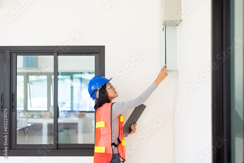Professional woman home Inspector surveyor wearing vests and hard hat at new house property