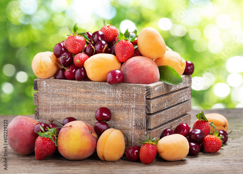 fresh  fruits in a wooden box on green background