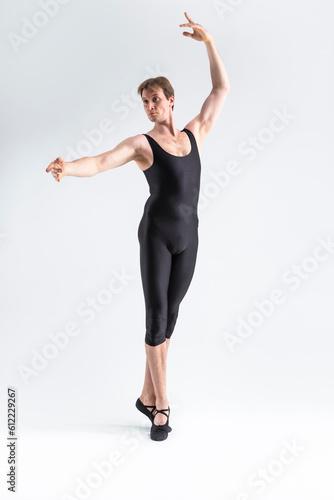 Caucasian Male Ballet Dancer Flexible Athletic Man Posing in Black Tights in Ballanced Dance Pose With Hands Lifted