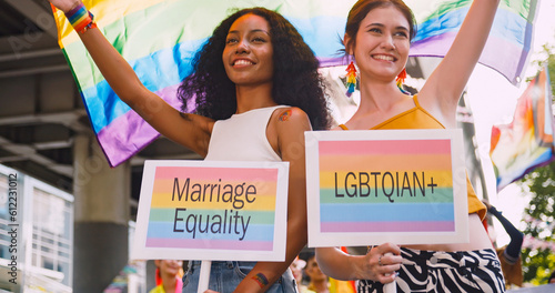 A lesbian couple waves a rainbow flag, a symbol of homosexuality, during a pride parade.