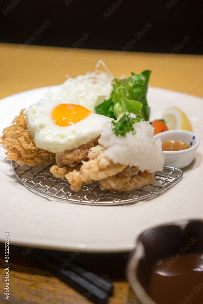 Close up of Japanese fried chicken with fried egg on wood table Close up of Japanese fried chicken with fried egg on wood table