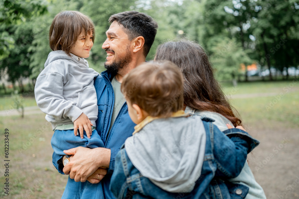Happy father and mother enjoying with children in park Happy father and mother enjoying with children in park
