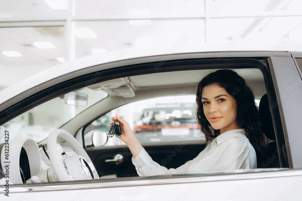 Young woman receiving the keys of her new car Young woman receiving the keys of her new car