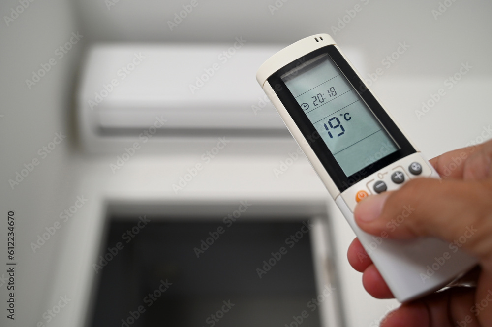 Réglage de la climatisation avec une télécommande en main Réglage de la climatisation avec une télécommande en main