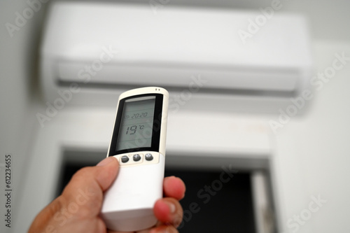 Obraz na plátně Réglage de la climatisation avec une télécommande en main