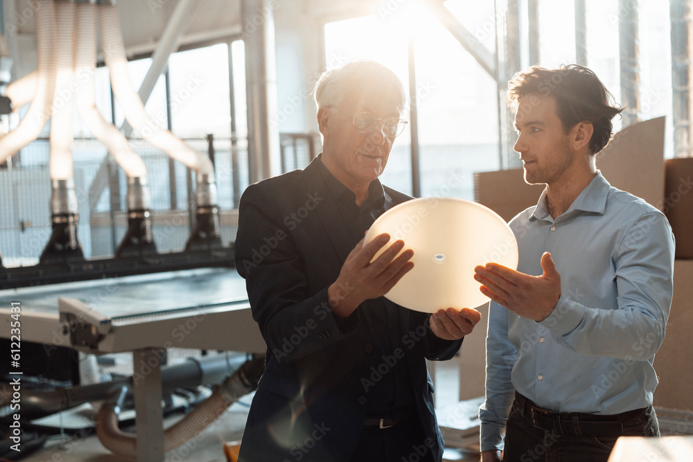 © Westend61 - Businessmen discussing over machine part in industry