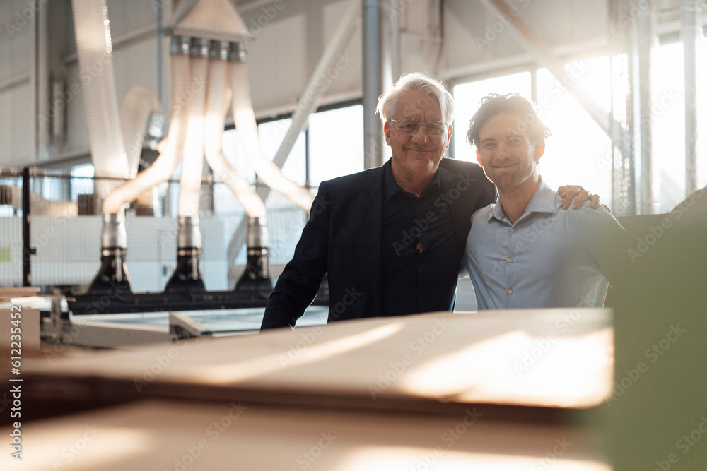 Smiling businessmen standing together in factory Smiling businessmen standing together in factory