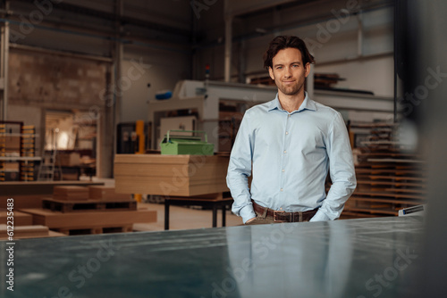 Smiling businessman standing in lumber industry photo