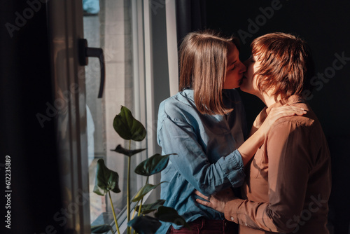 Affectionate lesbian couple kissing each other at home photo