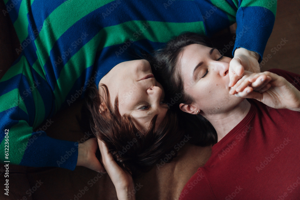 Woman kissing lesbian friend lying down at home Woman kissing lesbian friend lying down at home