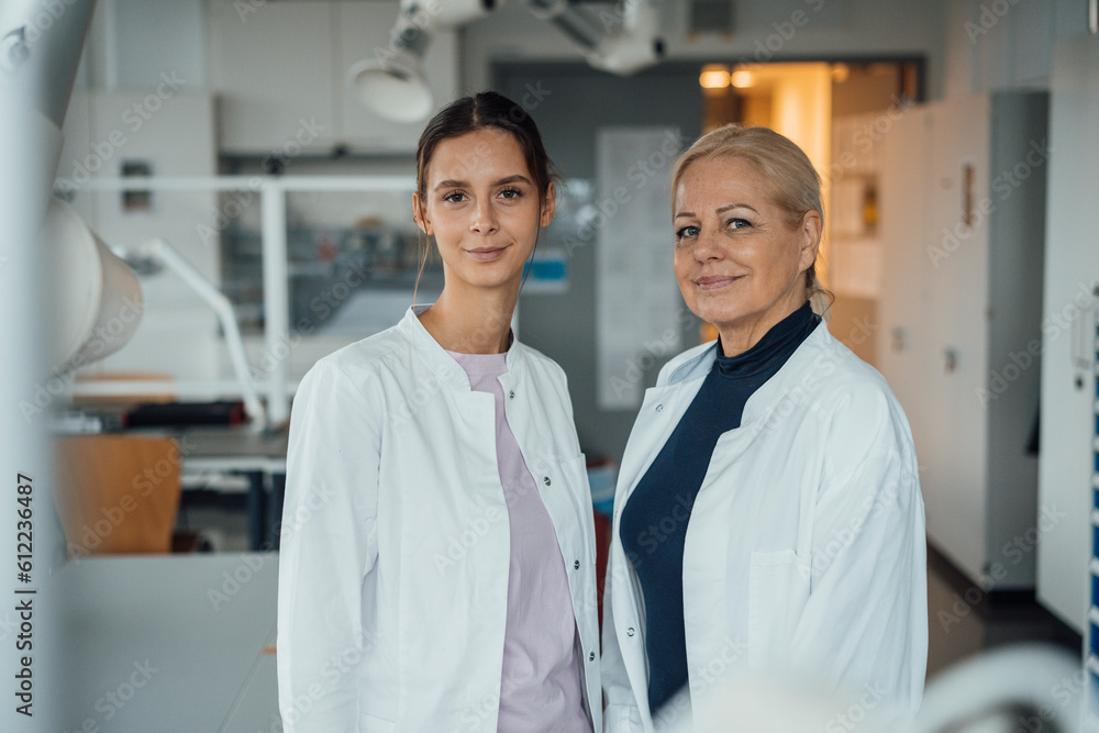 Smiling scientists standing in laboratory Smiling scientists standing in laboratory