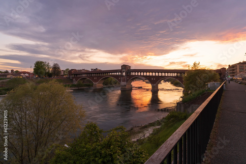 Ponte Coperto (covered bridge) over Ticino river in Pavia at sunset, Lombardy, italy.