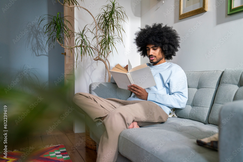 Man reading book sitting on sofa at home Man reading book sitting on sofa at home