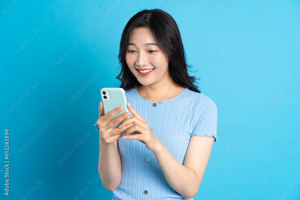 Portrait of smiling asian woman posing on blue background Portrait of smiling asian woman posing on blue background