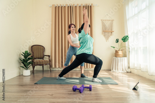Health care Asian woman plus size doing training yoga with personal trainer at home together. Healthy lifestyle and exercise weight loose.