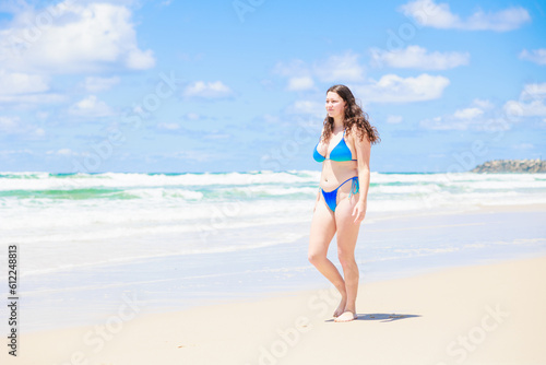 ビーチを歩く水着姿の外国人女性