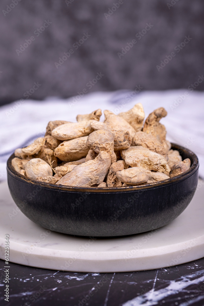 Ginger root on dark background. Ginger root in wooden bowl. Mixture of spices and dried herbs. Spice concept. Close up Ginger root on dark background. Ginger root in wooden bowl. Mixture of spices and dried herbs. Spice concept. Close up