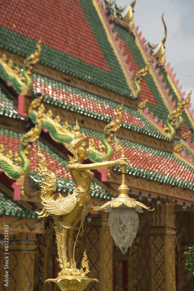 Thai style angle or Kinnari godess statue holding a lamp installed on the head of the pillar in Wat Maniwong Temple for beauty and orderliness. Located at Nakhon Nayok Province in Thailand.