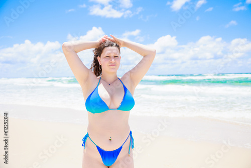髪の毛を束ねる水着姿の白人女性 © photok