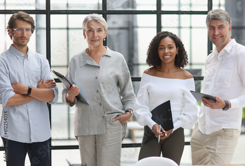 A group of young modern people in smart casual clothes, studying while working in the office