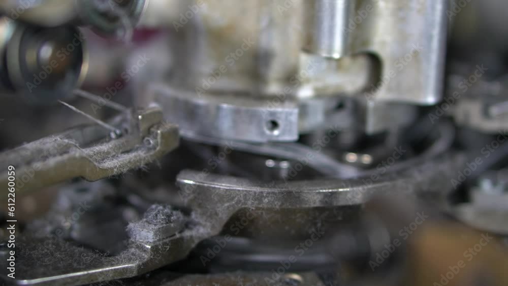 Close-up parts of the machine with threads, the Production process in a garment factory, automated process, manufacture of socks Close-up parts of the machine with threads, the Production process in a garment factory, automated process, manufacture of socks