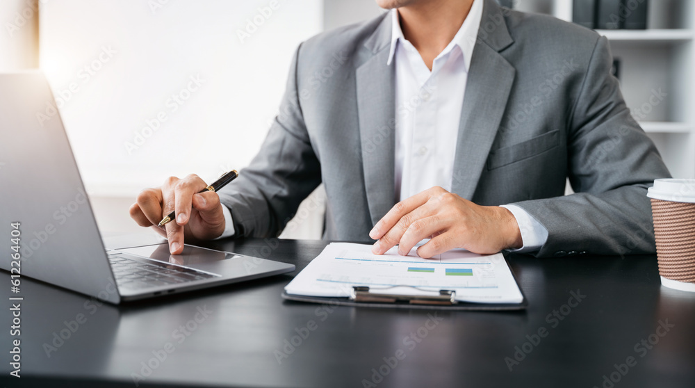 Asian businessman working at office with laptop and documents on table. Asian businessman working at office with laptop and documents on table.
